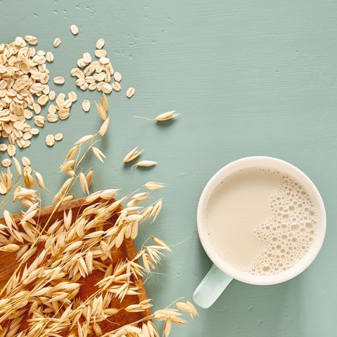 lait d'avoine dans un verre et une tasse sur fond bleu