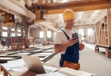 Top 7 des meilleurs téléphones de chantier en 2022 cheerful builder using smartphone at construction site