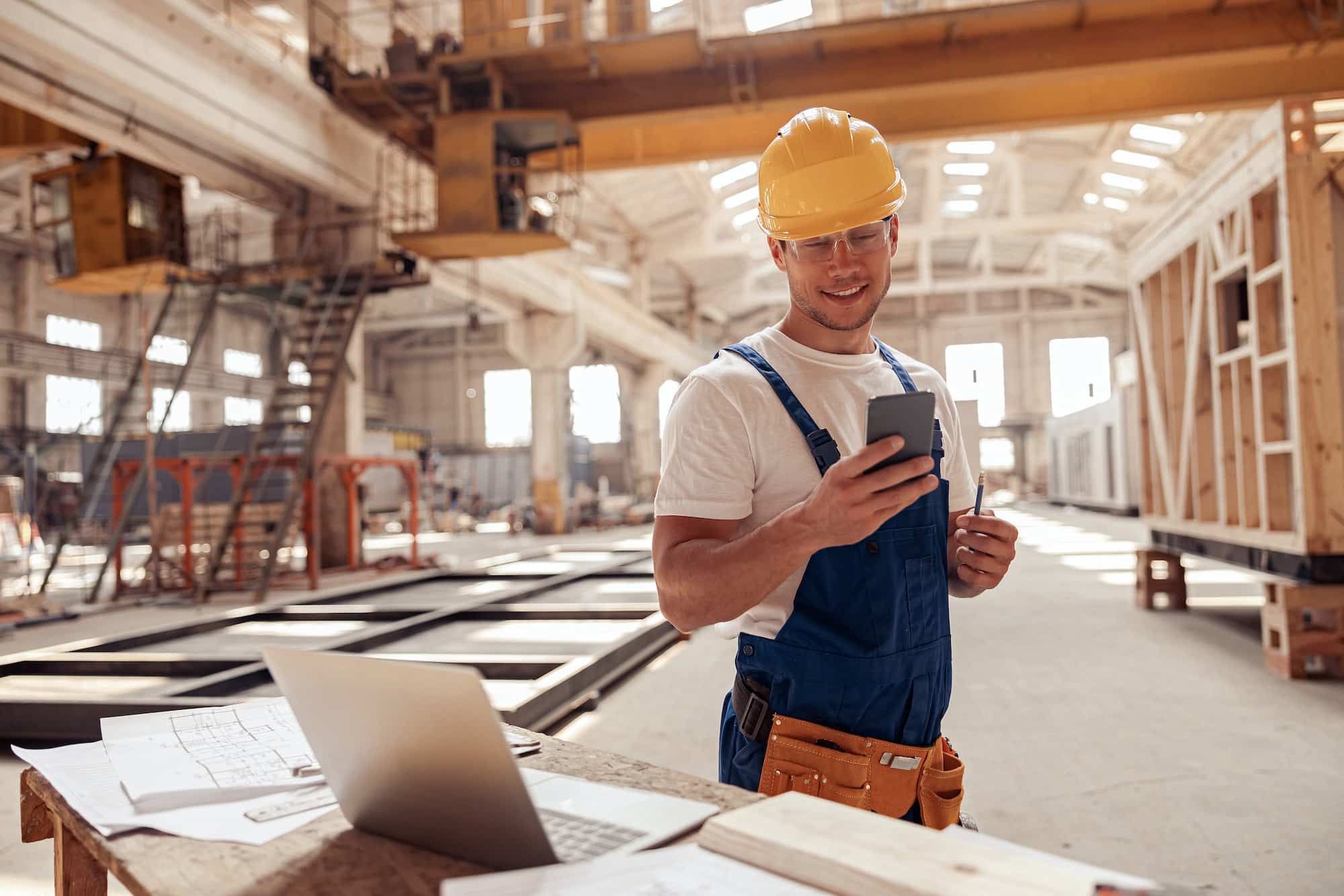 Top 7 des meilleurs téléphones de chantier en 2022 cheerful builder using smartphone at construction site