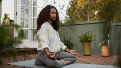 La méditation peut-elle réduire l'anxiété ? Conseils sur la façon de méditer pour l'anxiété young woman sitting in the lotus pose outside on royalty free image 1664817913