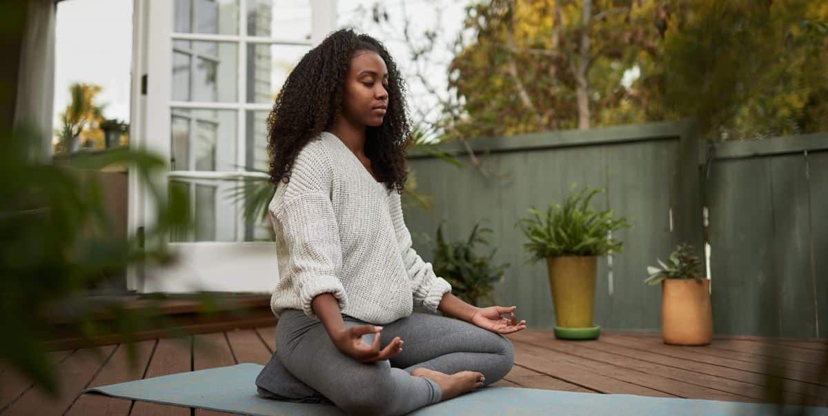 La méditation peut-elle réduire l'anxiété ? Conseils sur la façon de méditer pour l'anxiété young woman sitting in the lotus pose outside on royalty free image 1664817913