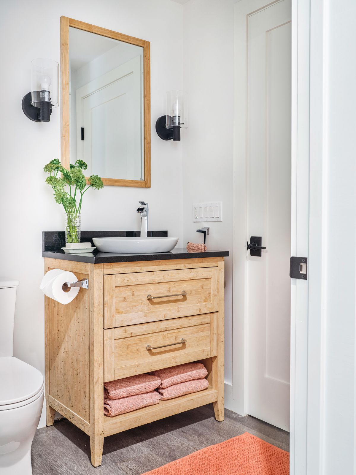 Bathroom furniture with wall sconces on the sides of the mirror