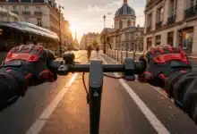 Gants renforcés noirs et rouges portés au guidon d’une trottinette électrique dans Paris
